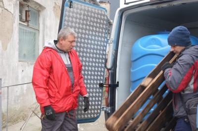 Сергій Рибальченко з колегою вивантажують питну воду та будівельні матеріали. Фото: інформаційне інтернет-видання «Суспільне Херсон»